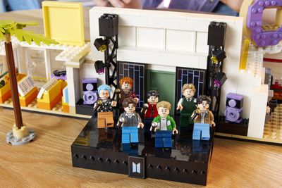 Επτά ειδώλια BTS σε μια μαύρη σκηνή Lego.