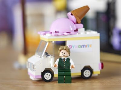 Αιδώλιο V Lego που κλείνει το μάτι μπροστά από ένα φορτηγό παγωτού Lego.