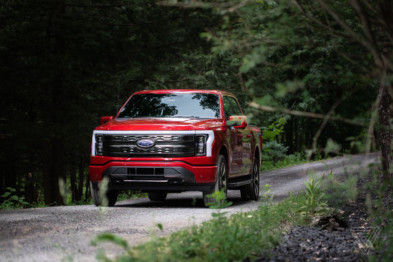 Ένα κόκκινο ηλεκτρικό φορτηγό Ford F-150 Lightning σε έναν δρόμο