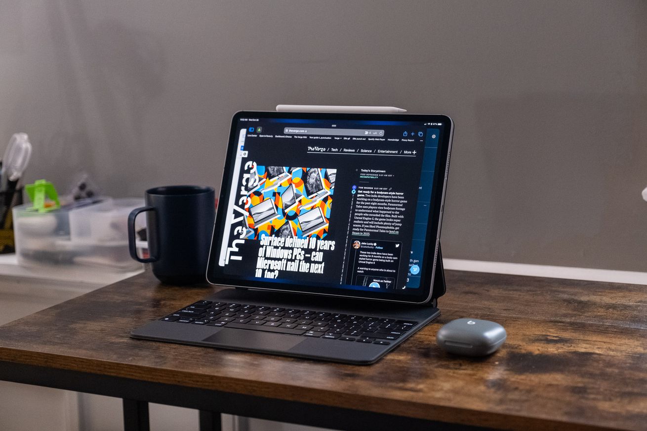 Ένα Apple iPad Pro 2022 σε θήκη Magic Keyboard σε ξύλινο γραφείο.