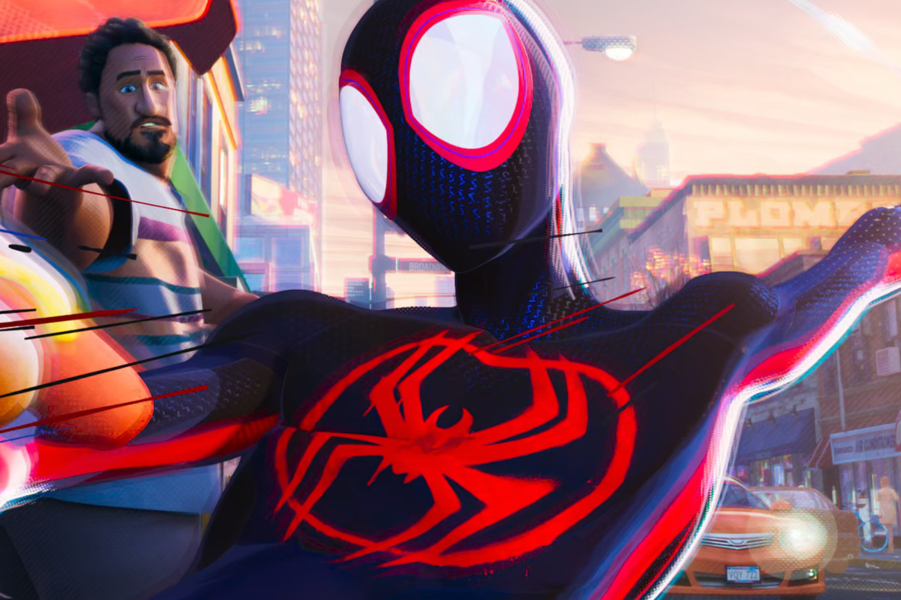 Ο Μάιλς Μοράλες με το κλασικό κοστούμι του Spider-Man αιωρείται προς την κάμερα καθώς αρπάζει ένα χοτ ντογκ από το χέρι ενός έκπληκτου πωλητή που κοιτάζει ακριβώς από πίσω του.